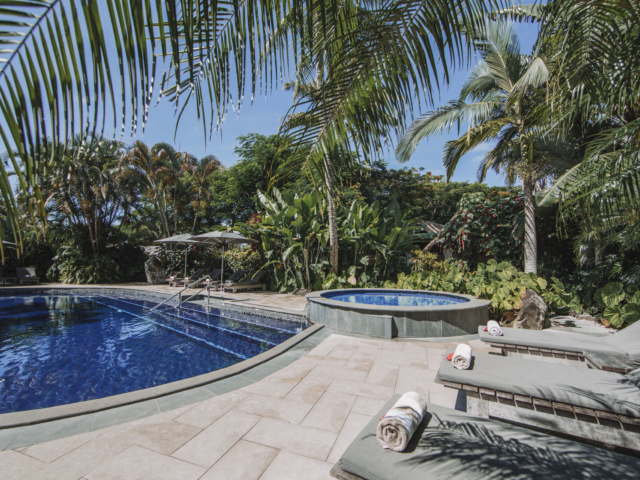 Resort swimming pool surrounded by lush tropical garden
