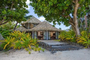 A stunning and luminous view of the Premium Beachfront Villa interior look from the beach showcasing a private garden with a stone-paved-walk way that leads to the beach