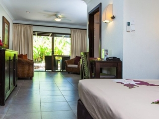 Premium Garden Suite view of the spacious lounge from the king bed featuring a contrasting yellow and green garden in the background