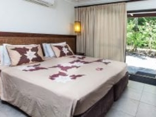 image of the Pacific Garden Suite super king bed capturing a side view of the front yard garden that brings a peaceful tropical getaway vibe