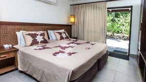 image of the Pacific Garden Suite super king bed capturing a side view of the front yard garden that brings a peaceful tropical getaway vibe