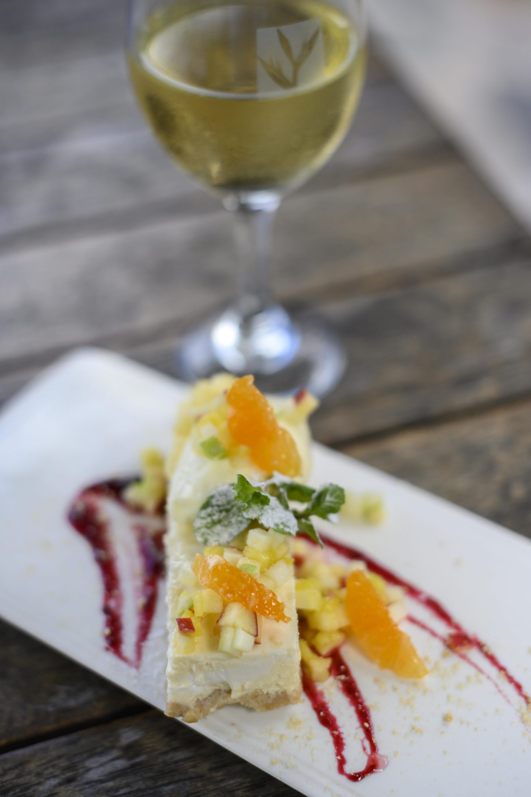 a delicious dessert garnished with thin slices of orange, served with a glass of white wine