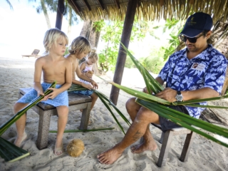 basket weaving demonstrated by a Beach Hut attendant to on-looking children
