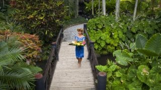 front view image of the delicious tropical fruit platter happily modelled by a resort staff walking in the midst of the breath-taking Pacific Resort lush garden
