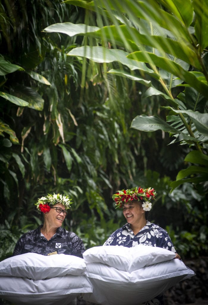 an image capturing two happy house keeping attendants proudly showcasing their housekeeping skills