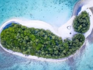 a stunning aerial image of the islets in the Muri lagoon capturing a heart symbol printed on a glowing white sandy beach