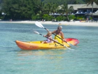 Image of mum enjoy coaching daughter, a toddler, the paddle moves on the paddle-board along the Muri Lagoon