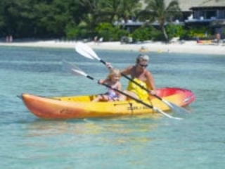 Image of mum enjoy coaching daughter, a toddler, the paddle moves on the paddle-board along the Muri Lagoon