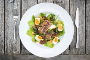 image of a healthy and delicious light lunch with contrasting colors served on a white plate, and a fork and knife placed on each side of the plate