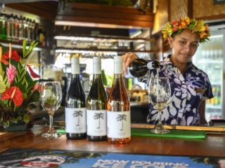 Bar attendant happily demonstrating her wine-pouring skills at the Sandals Bar