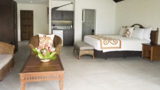 Interior image of the Premium Beachfront Suite showcasing the super king bed, spacious living room and a kitchenette