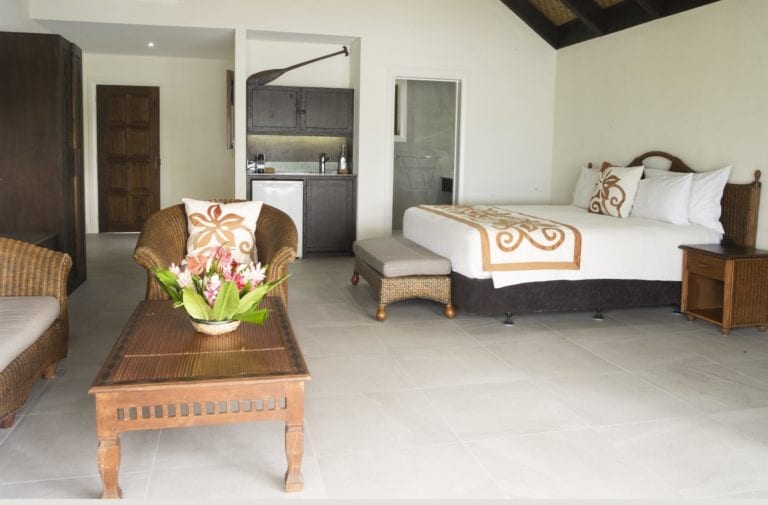 Interior image of the Premium Beachfront Suite showcasing the super king bed, spacious living room and a kitchenette